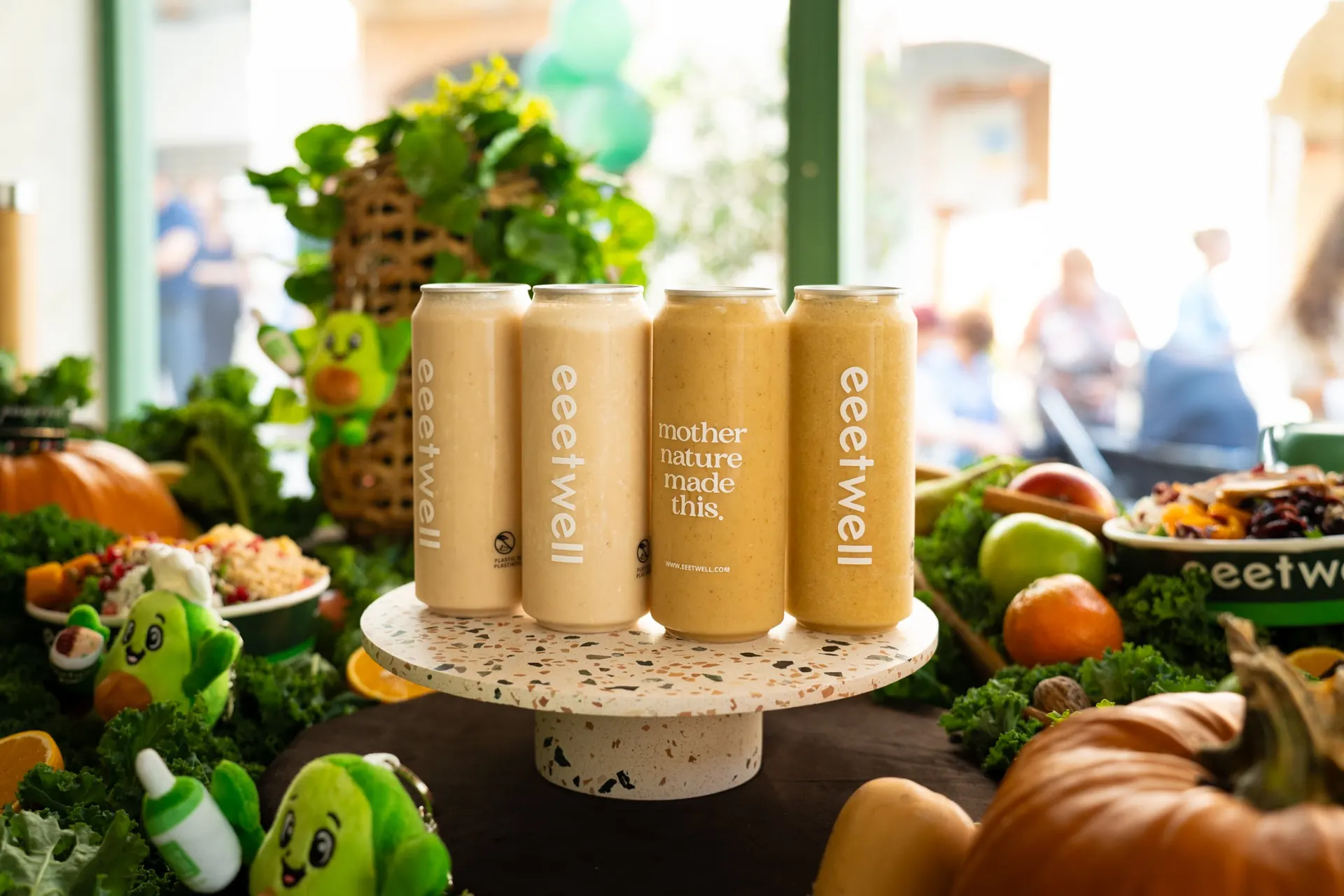 Four eeetwell smoothie cans on a stand